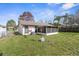 Spacious backyard featuring a grassy lawn and a screened-in patio, perfect for outdoor activities at 7810 Putnam Cir, New Port Richey, FL 34655