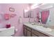 Bathroom featuring pink walls, vanity with sink, and vanity mirror at 7810 Putnam Cir, New Port Richey, FL 34655