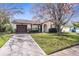 Charming single-story home featuring a well-maintained lawn, mature trees, and a private driveway at 7810 Putnam Cir, New Port Richey, FL 34655