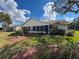 Backyard view of a home with lawn, landscaping, and screened in back porch at 8447 Pavilion Dr, Hudson, FL 34667