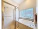 Bathroom featuring a large bathtub with a frosted glass shower and a large window at 8447 Pavilion Dr, Hudson, FL 34667