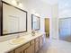 Bright bathroom with dual sinks, white cabinets, and a walk-in shower at 8447 Pavilion Dr, Hudson, FL 34667
