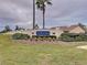 Welcoming entrance sign to The Estates community, framed by lush landscaping and swaying palm trees at 8447 Pavilion Dr, Hudson, FL 34667