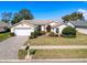 Charming single-story home features a manicured lawn, paved driveway, and attached two-car garage at 8447 Pavilion Dr, Hudson, FL 34667