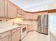 Traditional kitchen features stainless steel refrigerator and matching white appliances at 8447 Pavilion Dr, Hudson, FL 34667