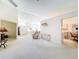 Spacious living room with neutral tones, a cozy chair, and access to the dining area at 8447 Pavilion Dr, Hudson, FL 34667