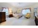 Vaulted ceiling main bedroom with neutral carpet, furnishings and windows at 8447 Pavilion Dr, Hudson, FL 34667