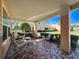 Covered patio with mosaic tiles, offering a relaxed outdoor living space with seating and barbecue grill at 9332 Whitstone Ct, New Port Richey, FL 34655