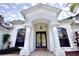 Close up of front entrance featuring double doors, columns, archway, and manicured landscaping at 10532 Alico Pass, New Port Richey, FL 34655