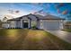 Charming single-story home boasts a manicured lawn, two-car garage, and inviting entryway with elegant columns at 12490 Meinert Ave, Brooksville, FL 34613