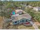 Aerial view of a light green house with a large pool, big detached garage and mature trees at 13083 Jaywalk Rd, Brooksville, FL 34614