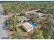 Aerial view of a house with an above ground pool and detached metal garage in a wooded neighborhood at 13083 Jaywalk Rd, Brooksville, FL 34614