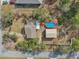 Birds eye view of a property with a swimming pool, detached garage, and lush surrounding landscape at 13083 Jaywalk Rd, Brooksville, FL 34614