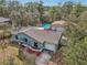 Aerial view of a one-story light-green house with a large pool, detached garage, and mature trees at 13083 Jaywalk Rd, Brooksville, FL 34614
