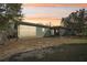 Backyard of a house with screened patio, large glass windows, and mature trees at 13083 Jaywalk Rd, Brooksville, FL 34614