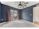 Carpeted bedroom with dark walls, a ceiling fan, sliding glass door, and access to a private pool at 13083 Jaywalk Rd, Brooksville, FL 34614