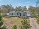 Exterior front view of light-green house with front lawn, red door, and attached garage at 13083 Jaywalk Rd, Brooksville, FL 34614