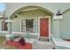 Close up shot of a red front door, light green exterior, and a tiled walkway at 13083 Jaywalk Rd, Brooksville, FL 34614