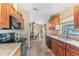 Open kitchen with wooden cabinets, granite countertops, and a view of the dining area at 13083 Jaywalk Rd, Brooksville, FL 34614