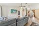 Open-concept living room featuring a comfortable gray sofa, ceiling fan, and wood-look tile flooring at 13083 Jaywalk Rd, Brooksville, FL 34614