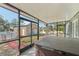 Enclosed patio view showcasing a hot tub and above-ground pool with outdoor garage in the background at 13083 Jaywalk Rd, Brooksville, FL 34614