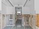 Hallway leading to the bathroom and kitchen, awaiting renovation with tile flooring at 13428 Sunfish Dr, Hudson, FL 34667