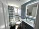 Bathroom featuring a single vanity, a tub with a shower, subway tile and an illuminated mirror at 13603 Jennita Dr, Hudson, FL 34667