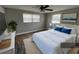 Bedroom featuring wood-look floors, a bed with blue pillows, two windows and a ceiling fan at 13603 Jennita Dr, Hudson, FL 34667