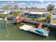 Exterior view of waterfront home with private dock featuring a boat lift and a sun-drenched backyard at 13603 Jennita Dr, Hudson, FL 34667