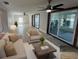 Bright living room featuring tile floors, modern ceiling fans, neutral-toned furniture and sliding glass doors to outdoor seating at 13603 Jennita Dr, Hudson, FL 34667