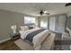 Primary bedroom featuring a ceiling fan, wood-look floors, a large window and a king-size bed with neutral bedding at 13603 Jennita Dr, Hudson, FL 34667