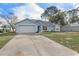 This single-story home features a spacious driveway, attached garage, and a well-manicured lawn at 1474 Godfrey Ave, Spring Hill, FL 34609