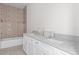 Bright new bathroom featuring tiled shower-tub combo and double vanity with granite countertop at 18020 Macek Rd, Weeki Wachee, FL 34614