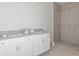 New bathroom featuring double vanity with granite countertop and tiled shower with pebble floor at 18020 Macek Rd, Weeki Wachee, FL 34614