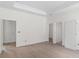 Bright bedroom featuring light wood floors, white walls and trim, and several white doors at 18020 Macek Rd, Weeki Wachee, FL 34614