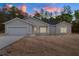 Charming single-story home featuring a two-car garage, and an inviting front entrance at dusk at 18020 Macek Rd, Weeki Wachee, FL 34614