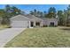 Charming single-story home featuring a two-car garage, well-manicured lawn, and inviting front entrance at 18020 Macek Rd, Weeki Wachee, FL 34614