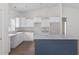 Well-lit kitchen featuring white cabinets, grey countertops, and a navy blue kitchen island at 18020 Macek Rd, Weeki Wachee, FL 34614