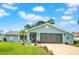 Charming light blue home with a well-manicured lawn, complemented by a two-car garage and lovely landscaping at 2089 Cottondale Ave, Spring Hill, FL 34608