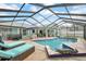 Screened pool area featuring a lounge area with an umbrella, hot tub and an alligator statue near the pool at 2089 Cottondale Ave, Spring Hill, FL 34608