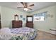 A quaint bedroom featuring light green walls, carpet flooring, ceiling fan and two dark wooden dressers at 2334 Gimlet, Spring Hill, FL 34608
