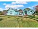 Charming turquoise home with a well-manicured lawn and a bright red front door, perfect for a Gathering at 2334 Gimlet, Spring Hill, FL 34608