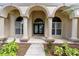 Elegant arched entryway with decorative glass double doors and lush landscaping leading to the front door at 2501 Oak Landing Dr, Brandon, FL 33511