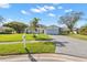 Well-maintained single-Gathering home showcasing a lush front lawn, palm trees, and an attached garage at 2862 Lomond Dr, Palm Harbor, FL 34684