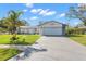 Beautiful single-story home with a vibrant green lawn, lovely landscaping, and an attached garage at 2862 Lomond Dr, Palm Harbor, FL 34684