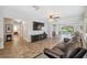 Bright living room featuring tile floors, ceiling fan, tv, comfortable seating, and access to outdoor patio at 2862 Lomond Dr, Palm Harbor, FL 34684