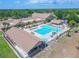 An aerial view of a large community pool with sundeck, and clubhouse amenities surrounded by palm trees at 2862 Lomond Dr, Palm Harbor, FL 34684