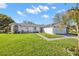 Relaxing screened porch with ceiling fan, comfortable seating, and a view of the serene pond at 2862 Lomond Dr, Palm Harbor, FL 34684