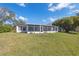 A screened lanai and large manicured yard are featured at the rear of this single-story home at 2862 Lomond Dr, Palm Harbor, FL 34684