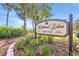 A sign is placed at the Highland Lakes Golf Club entrance featuring manicured flower beds and trees at 2862 Lomond Dr, Palm Harbor, FL 34684